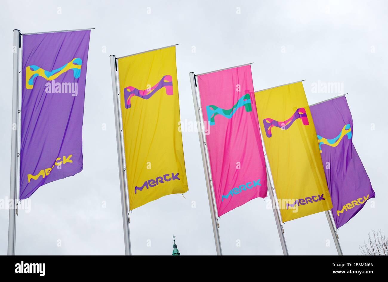 Line of colorful flags with the Merck logo. Merck KGaA is one of the largest pharmaceutical companies in the world. Darmstadt, Germany. Stock Photo