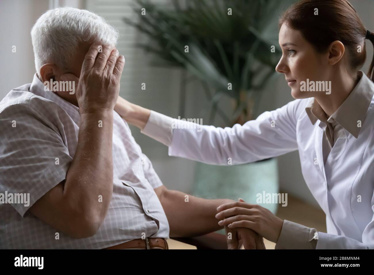 Young nurse caring about 80s patient provide support relieves loneliness Stock Photo