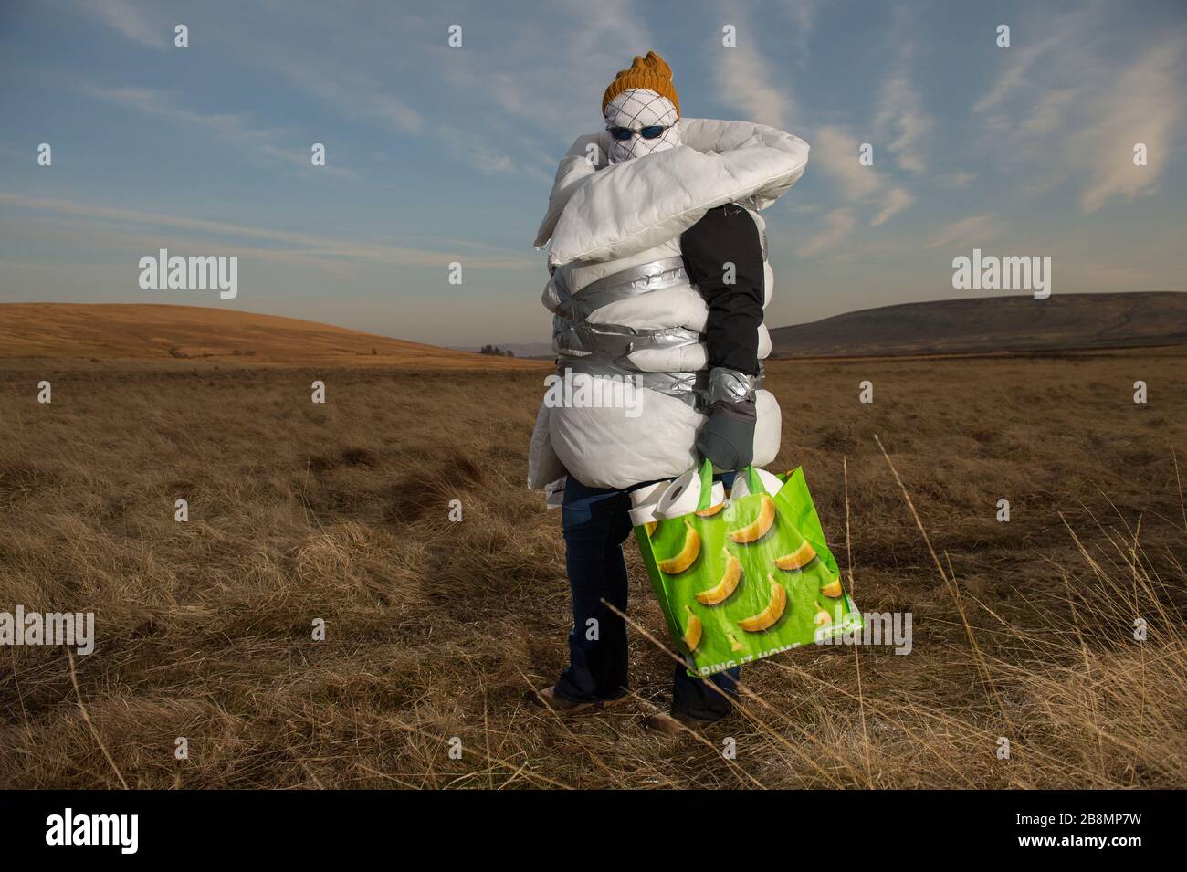 Perthshire Hills, UK. 22nd Mar, 2020. Pictured: Concept picture of a person going to extreme lengths to self isolate in the middle of nowhere carrying the most sought after item in the world of toilet paper, whilst wrapped up in home made personal protective equipment. Credit: Colin Fisher/Alamy Live News Stock Photo