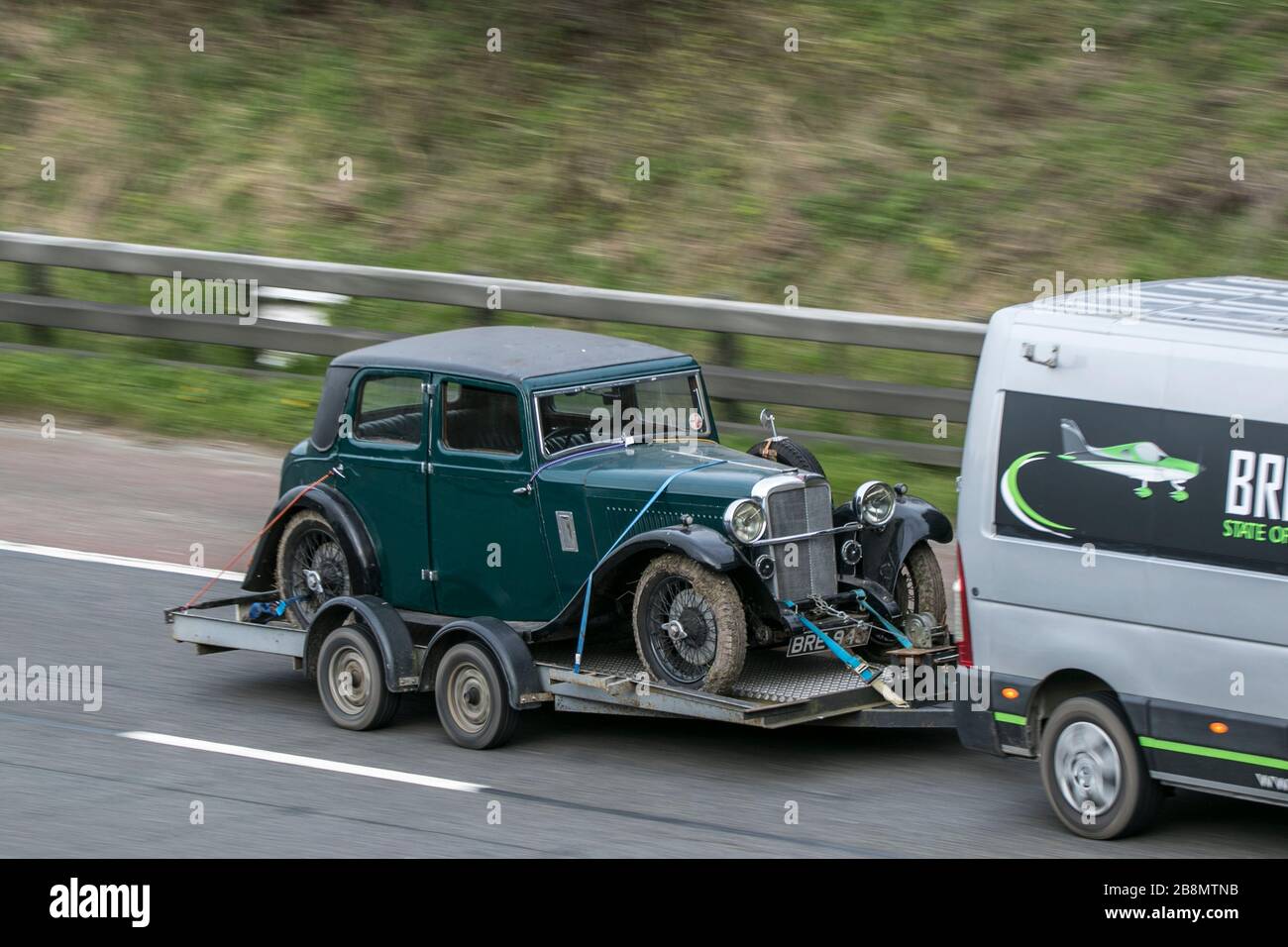 Old Green Alvis sedan classic cars old barn find, heritage restoration project vehicle being towed on the M6 motorway near Preston in Lancashire, UK Stock Photo