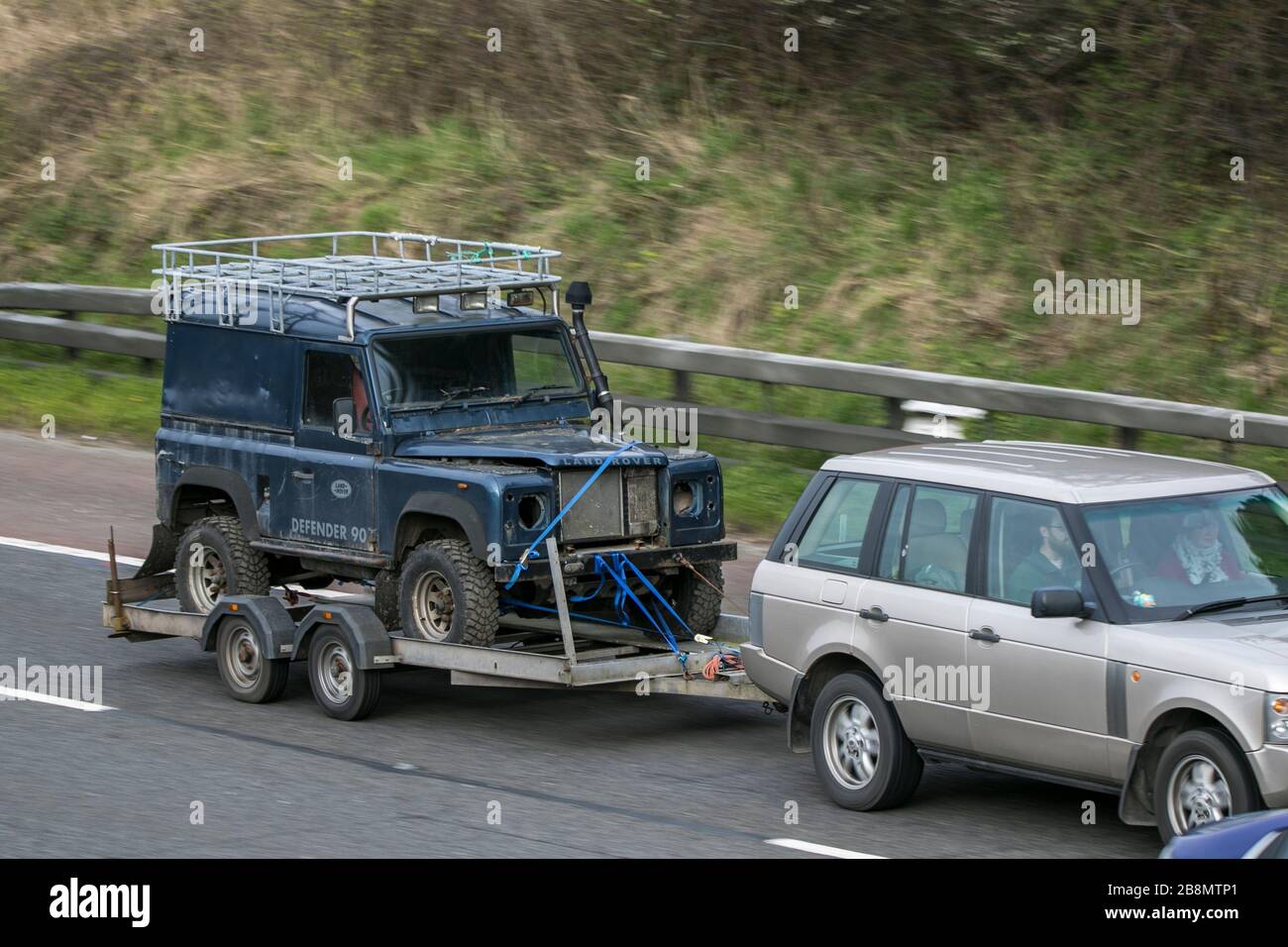 Old relic Land Rover Defender on trailer driving on the M6 motorway near Preston in Lancashire, UK Stock Photo