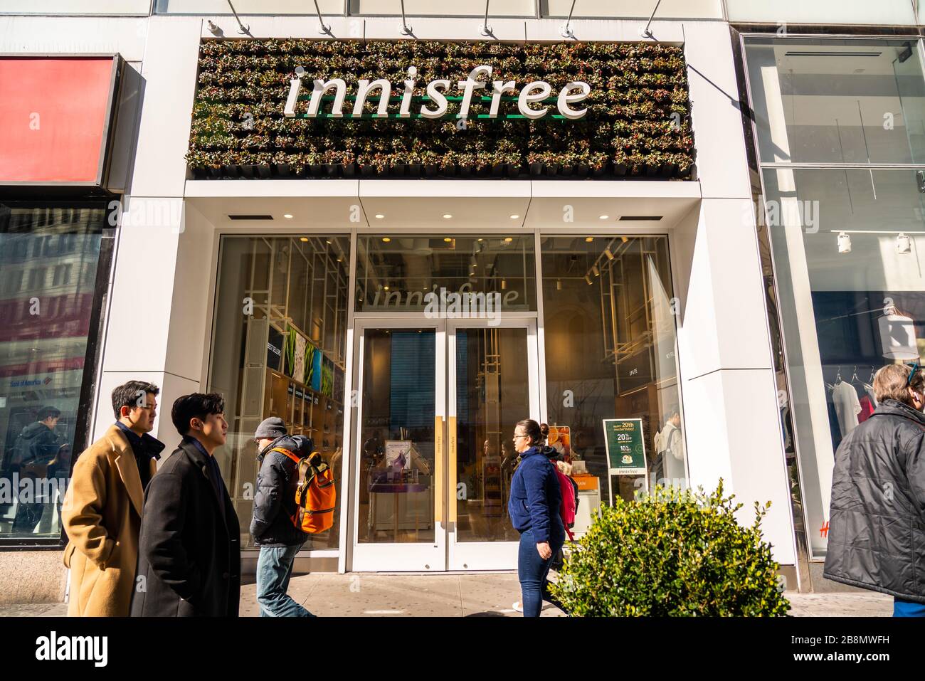 Pedestrians walk past a South Korean cosmetics brand Innisfree store in