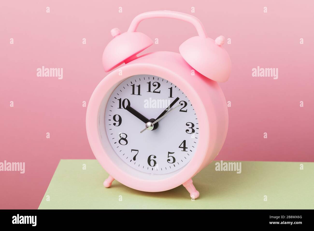 Alarm clock on a pink background, close-up Stock Photo