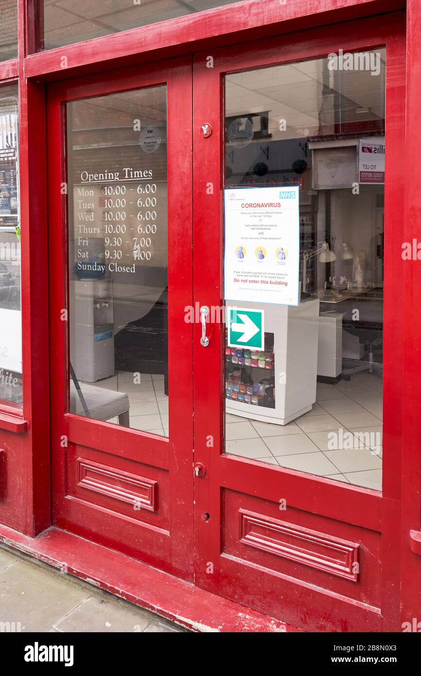 Covid-19 Coronavirus information poster in shop door window Stock Photo