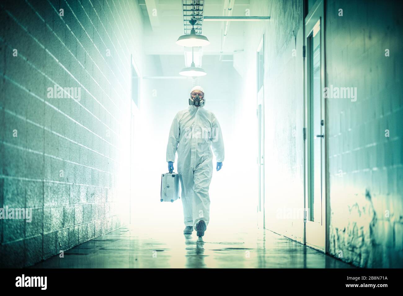 corona virus concept. male doctor waliking in coridor with biohazard case Stock Photo
