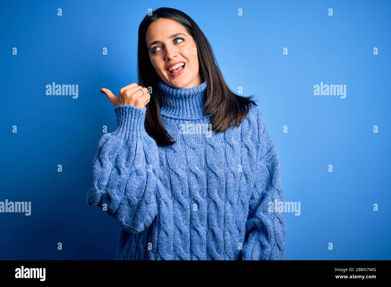 Young brunette woman with blue eyes wearing casual turtleneck sweater ...