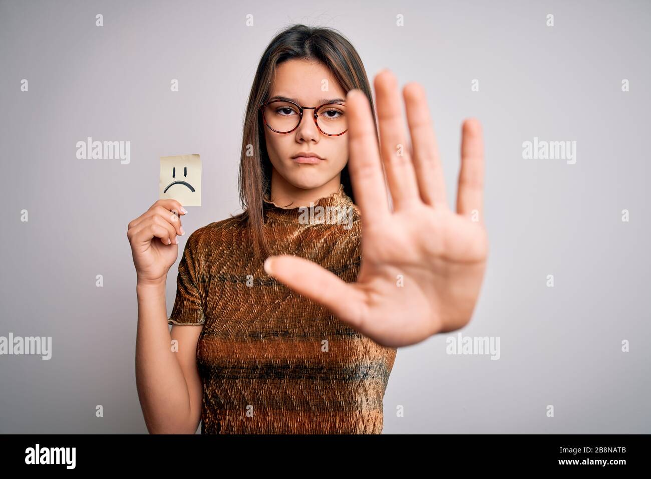 Young Beautiful Girl Holding Reminder With Sad Emotion Emoji Face Over White Background With Open Hand Doing Stop Sign With Serious And Confident Expr Stock Photo Alamy