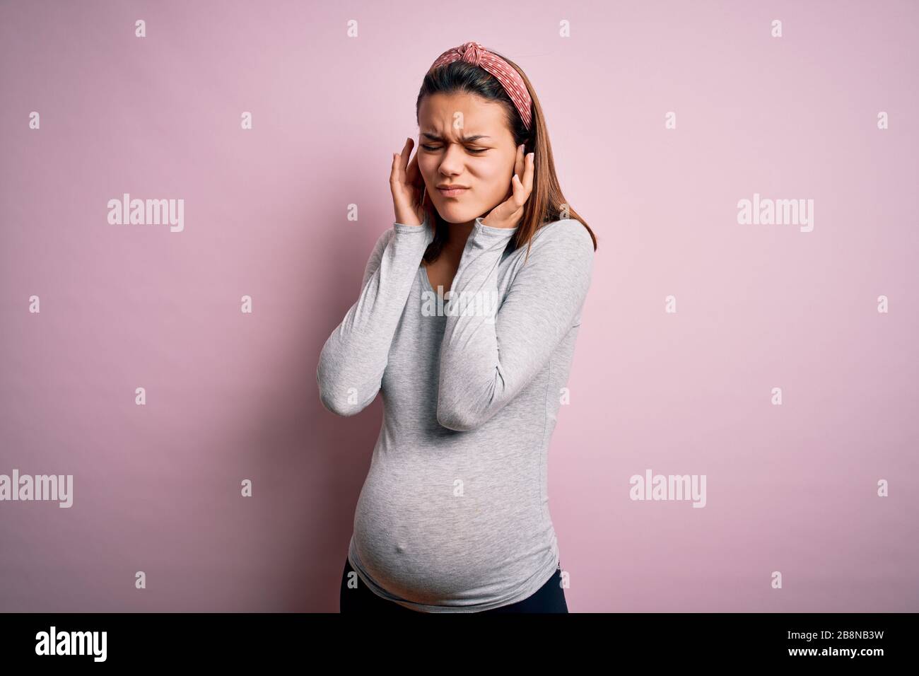 Young beautiful teenager girl pregnant expecting baby over isolated