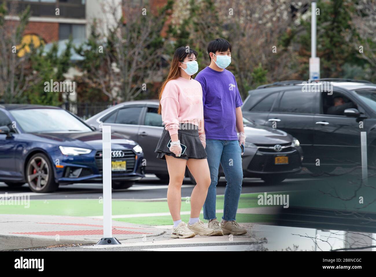 Jersey City, New Jersey, USA. 22nd Mar, 2020. Asian Americans wear protective masks and gloves as they walk the streets of Jersey City, New Jersey. Mandatory credit: Kostas Lymperopoulos/CSM/Alamy Live News Stock Photo