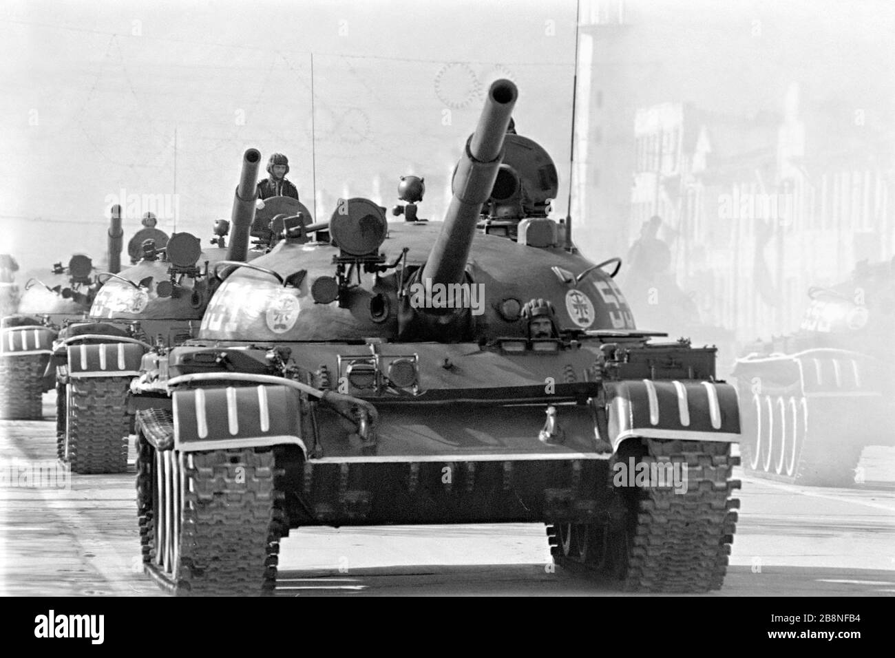 Afghan soldiers ride a Soviet-made T-62 main battle tank during a military parade to mark the tenth anniversary of the communist revolution April 26, 1988 in Kabul, Afghanistan. The communist regime took power in a revolt known as the Saur Revolution backed by the Soviet Union. Stock Photo