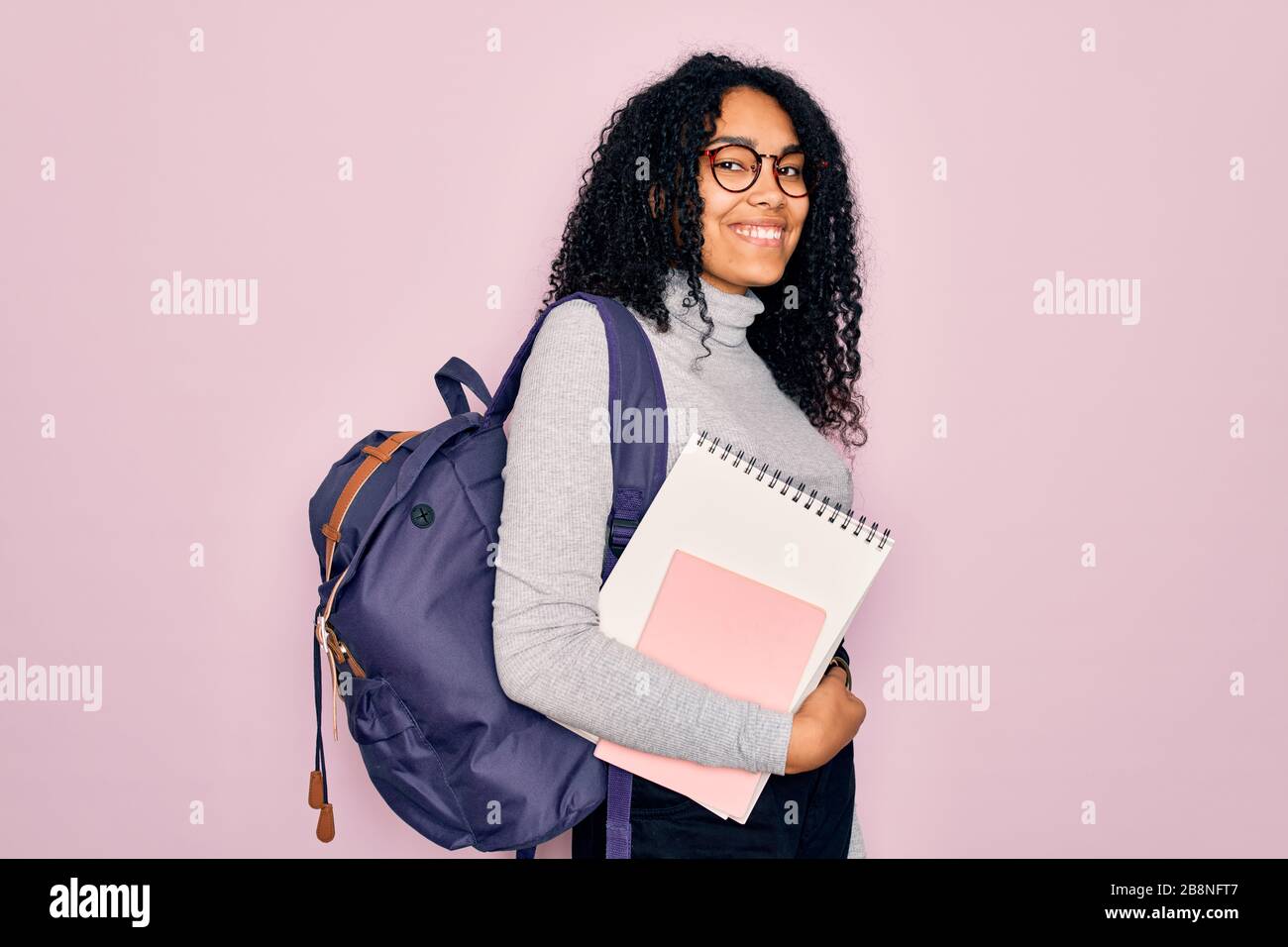 Young african american curly student woman wearing backpack and glasses ...