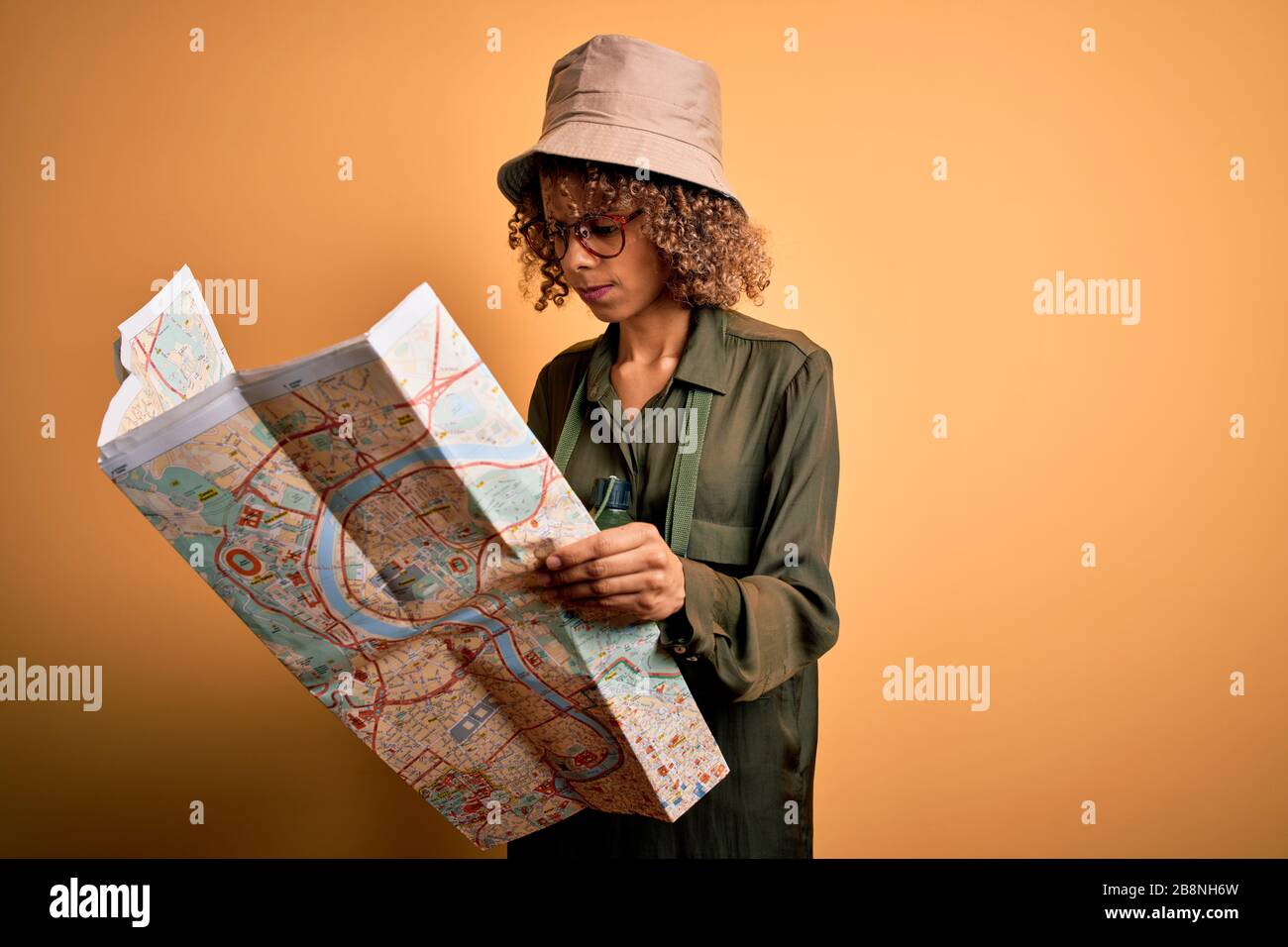 African american tourist woman wearing explorer hat and water canteen ...