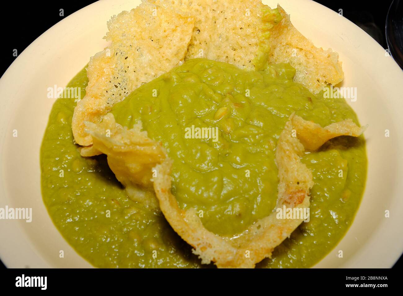 Italian grourmet plat with parmesan cheese and a velvety of peas Stock Photo