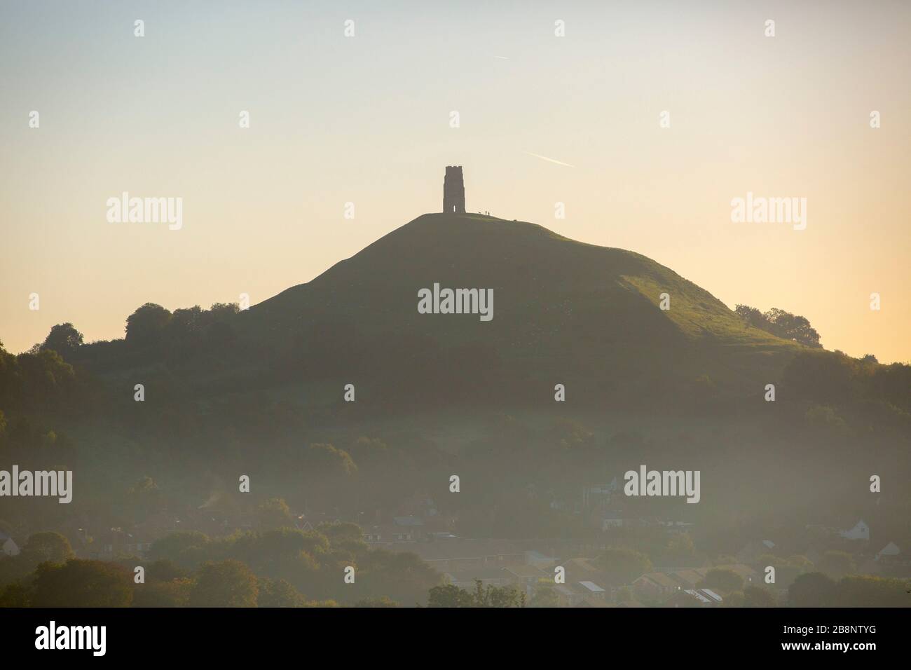 The autumn sun is seen rising over Glastonbury Tor and the Somerset levels. 27th September 2015. Stock Photo