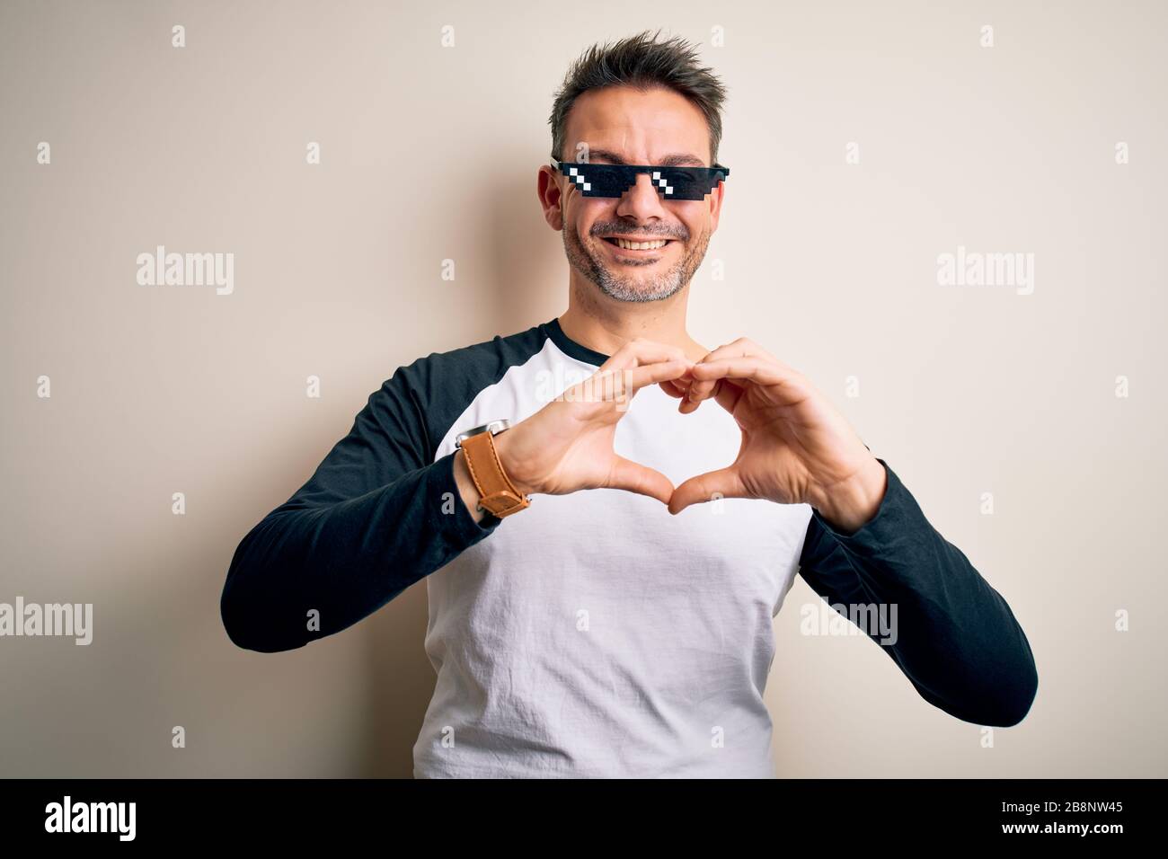 Young handsome man wearing funny thug life sunglasses meme over white  background smiling in love showing heart symbol and shape with hands.  Romantic c Stock Photo - Alamy