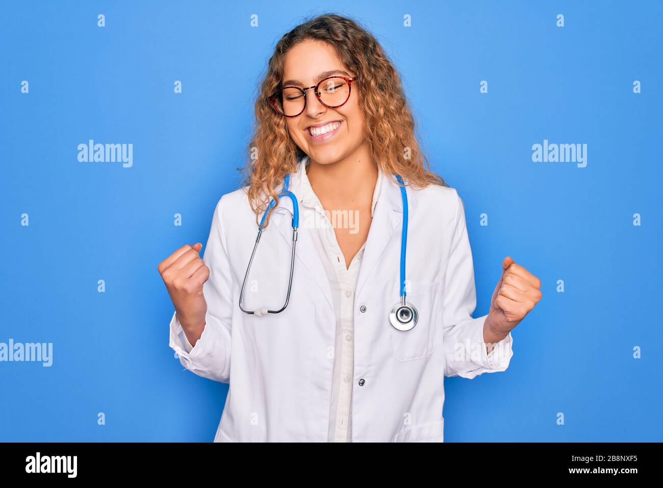 Young beautiful blonde doctor woman with blue eyes wearing coat and ...
