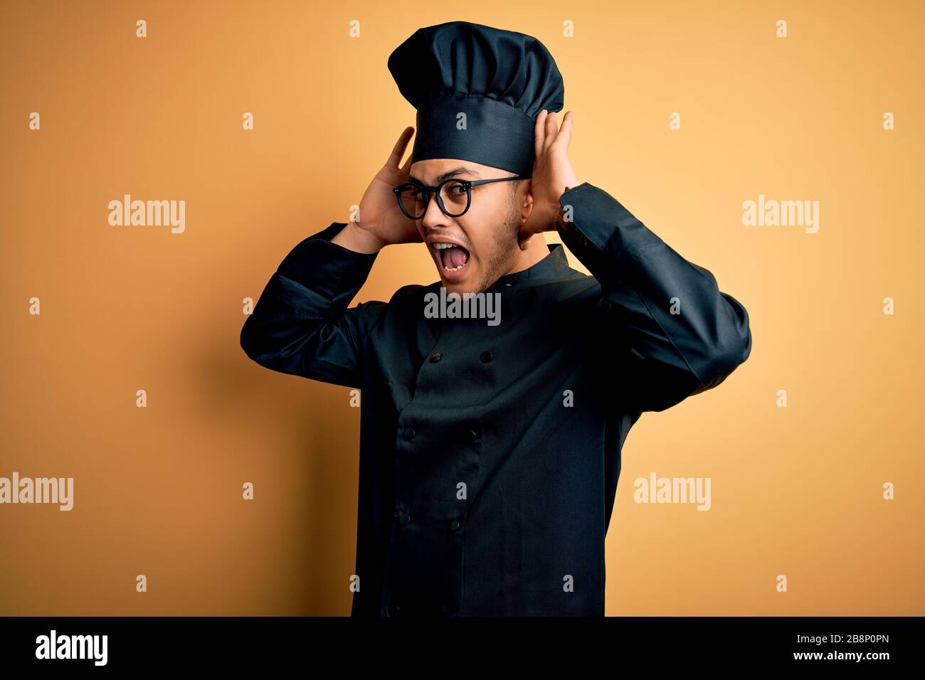 Young brazilian chef man wearing cooker uniform and hat over isolated ...