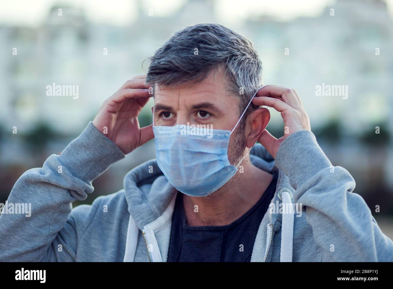 A portrait of man with medical face mask outdoor. People, healthcare ...
