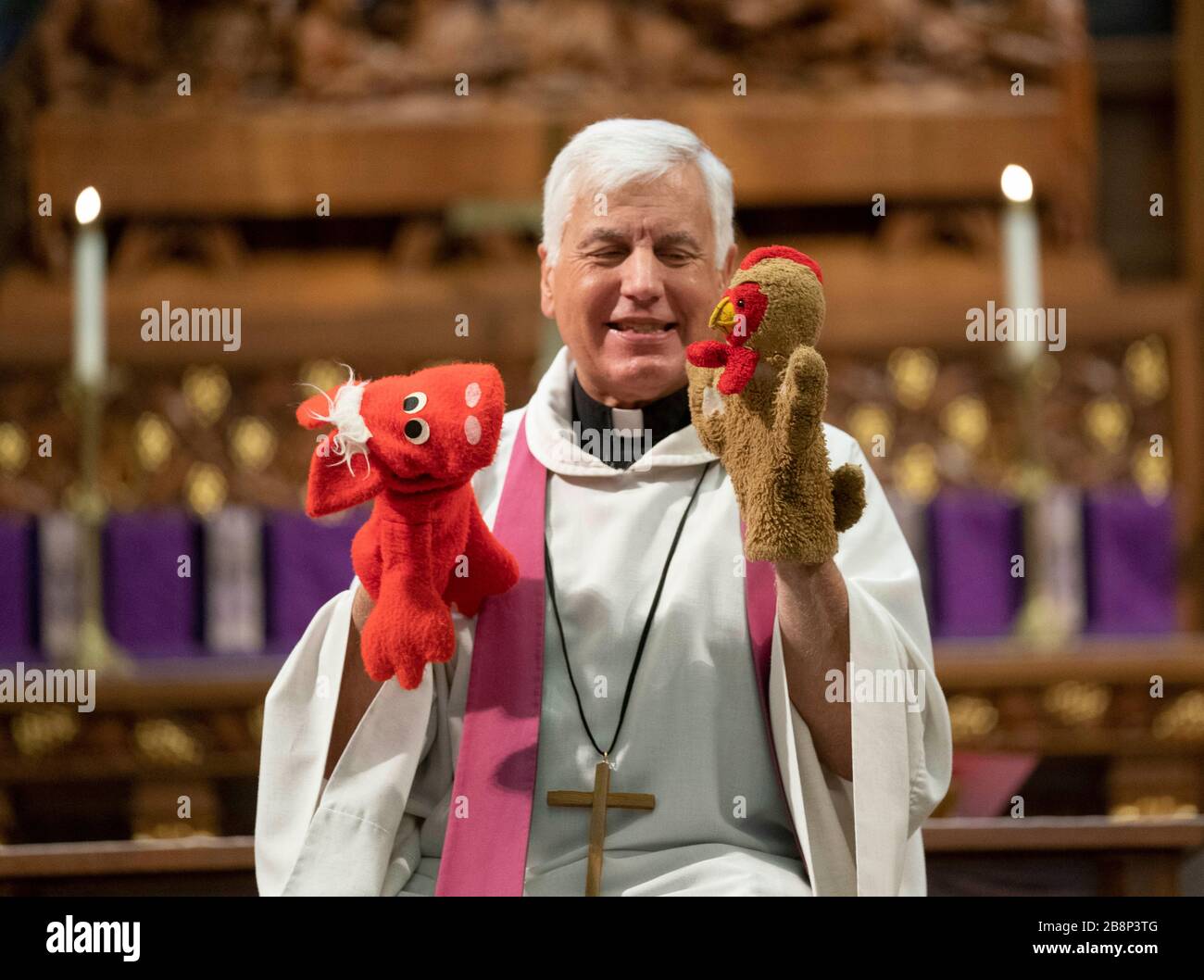 Austin, TX USA March 22, 2020: Pastor John Van Haneghan of Saint Martin's Lutheran Church performs a children's message with puppets to an empty sanctuary that would normally hold several hundred worshipers on a Sunday morning in downtown Austin. The church is offering online services while crowd restrictions are in place due to the coronavirus pandemic. Credit: Bob Daemmrich/Alamy Live News Stock Photo
