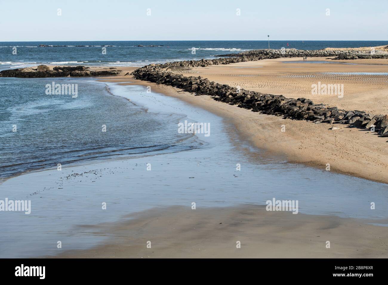 Small sandy beach jutting out in Seabrook, NH. Atlantic Ocean on low tide. This is Beakmans Point at low tide. Great summer destination for all. Stock Photo