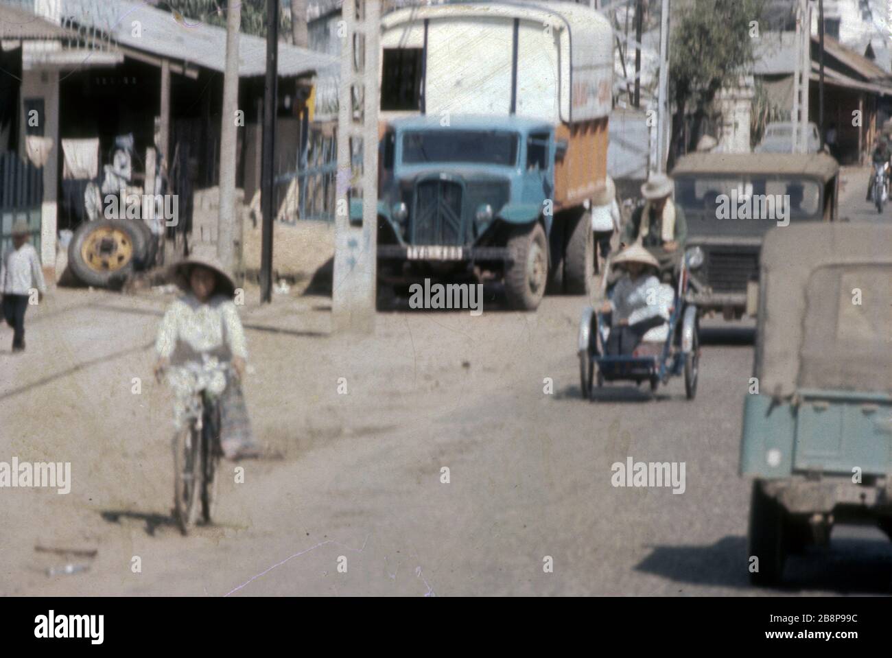 Vietnam, 1968, Small local town near Danang with local women on a bicycle and a rickshaw during the war. Stock Photo