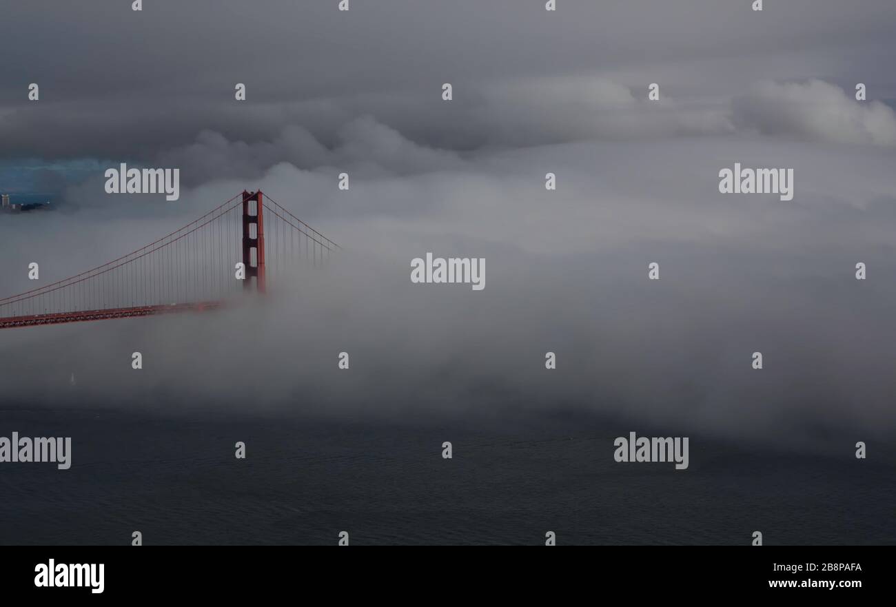 Golden Gate Bridge partially obscured by fog at dusk, San Francisco, California, United States, North America, color Stock Photo