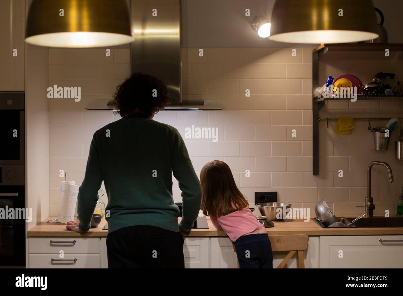 Young father and little child girl, profile view, cooking together