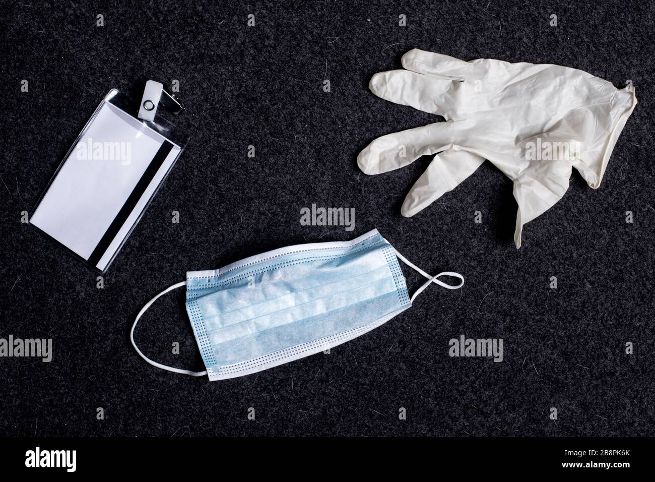 Surgical masks, gloves and ID card on a hospital floor Stock Photo