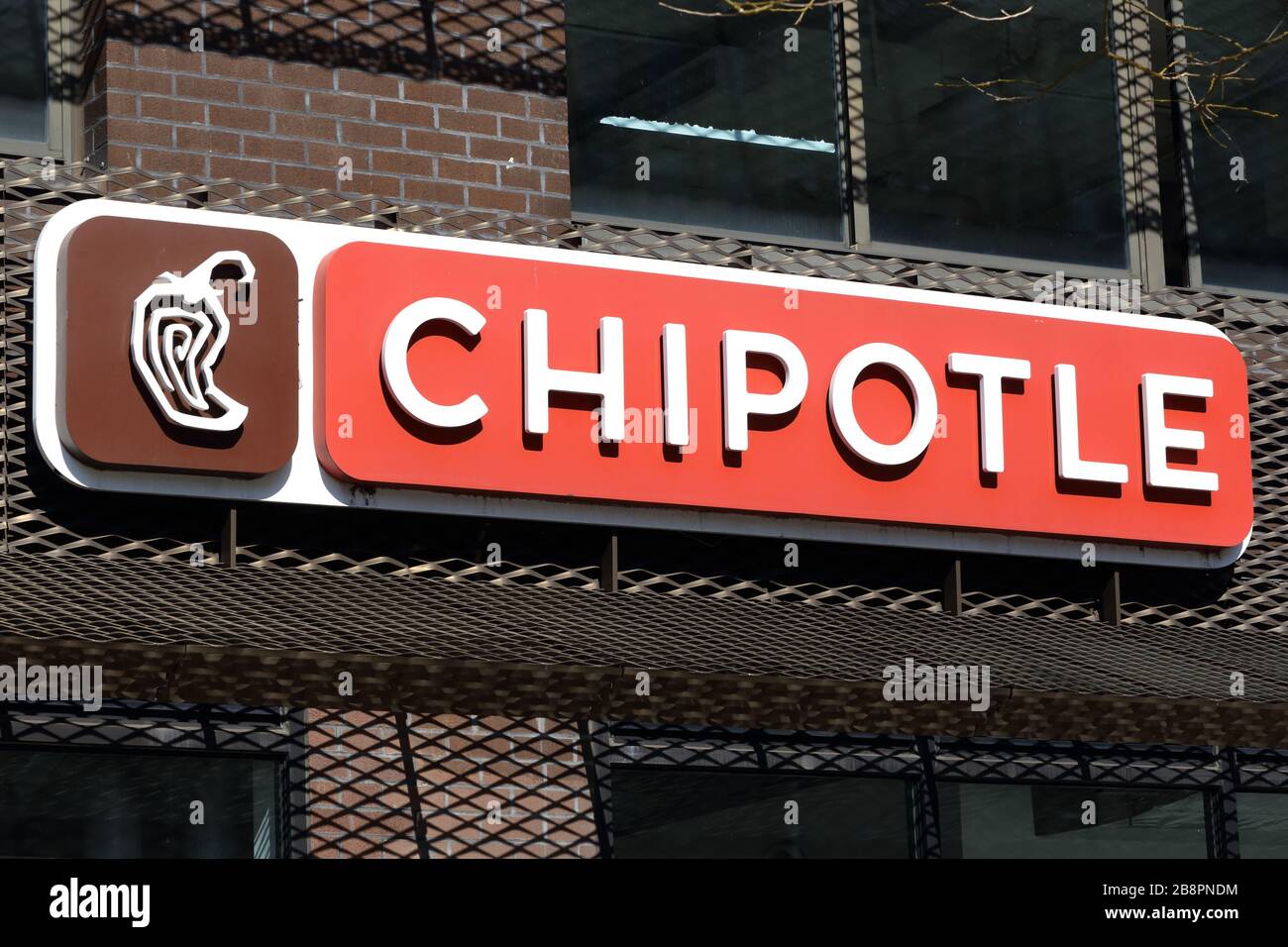 A Chipotle sign on a wall at one of their stores Stock Photo
