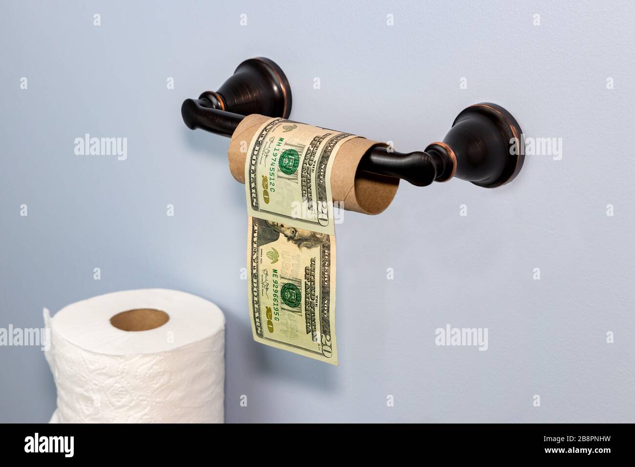 Empty toilet paper roll wrapped in 20 dollar bills. Concept of supply shortage, hoarding, price gouging during Covid-19 coronavirus worldwide pandemic Stock Photo