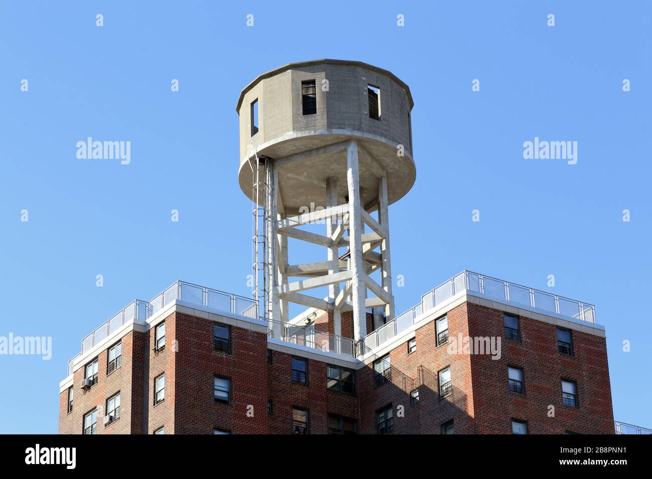 A wooden water tank on a concrete platform on top of a building in the