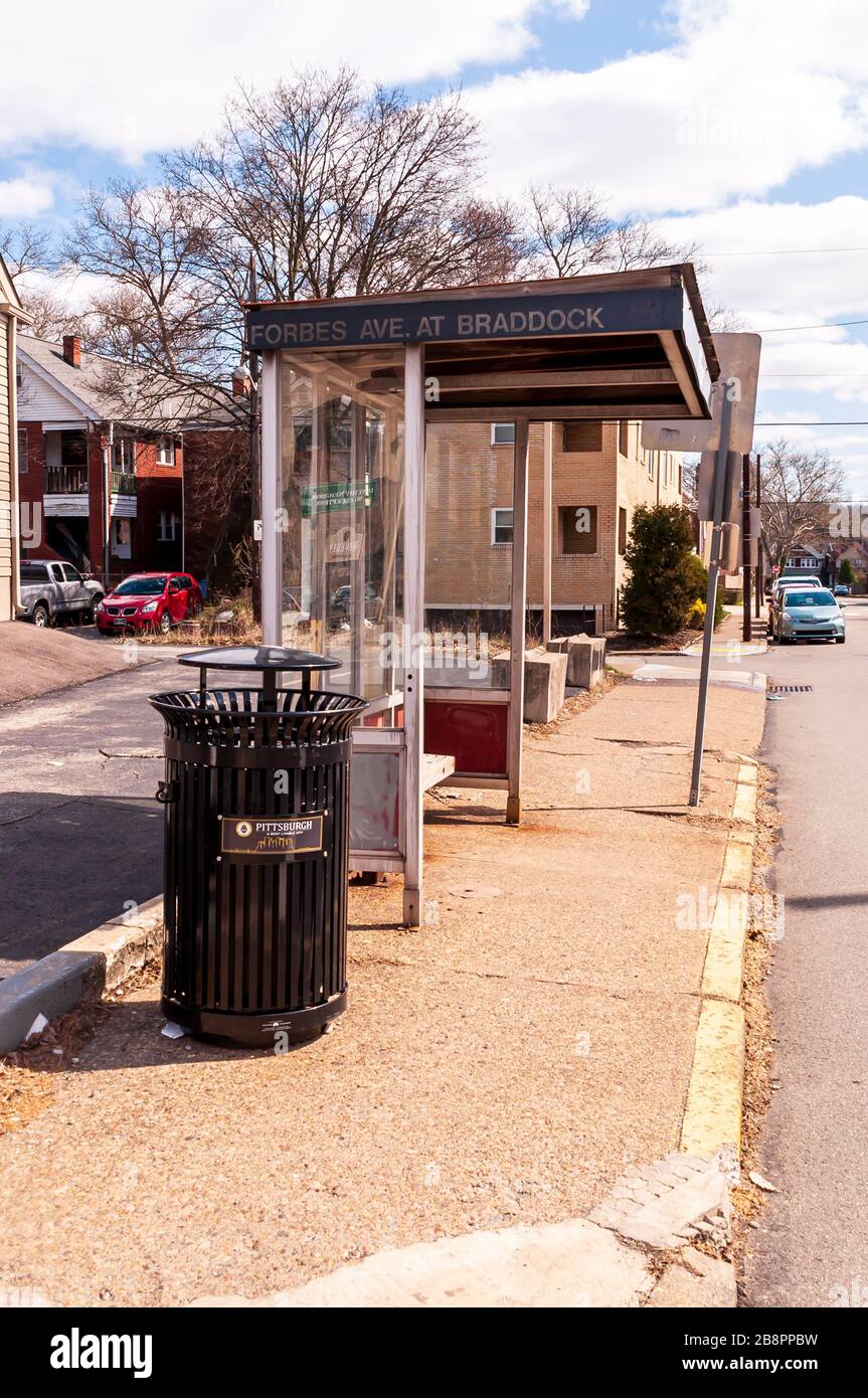 A bus shelter on Forbes Avenue with a City of Pittsburgh garbage can