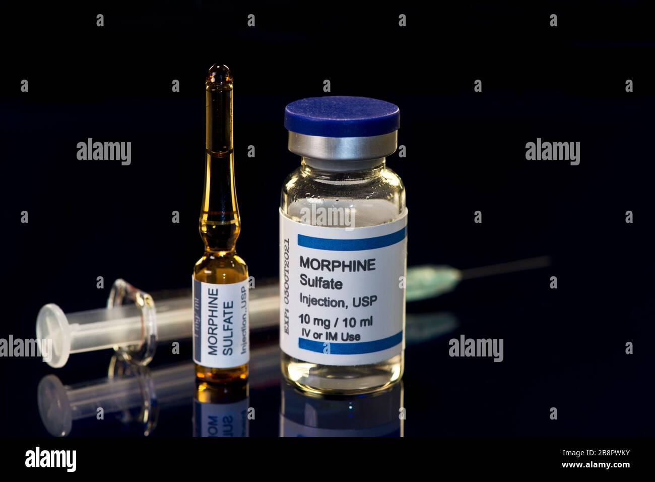 Morphine sulfate vial and ampule and syringe on black refelctive surface. Stock Photo
