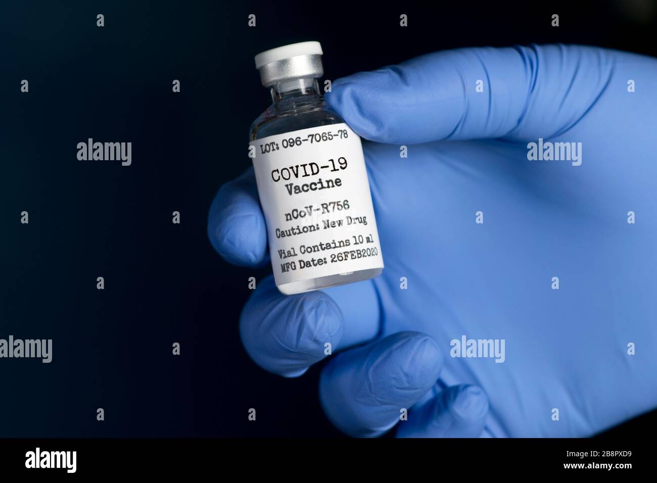 Coronavirus Covid-19 vaccine vial in gloved hand of nurse on dark background. Stock Photo