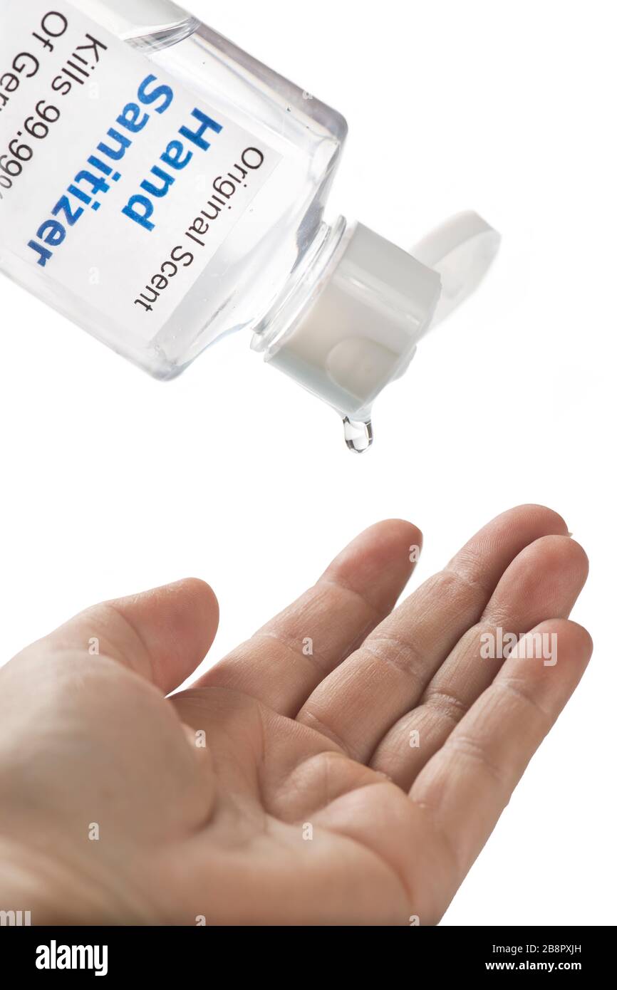 Hand Sanitizer container applying alcohol based anti-viral sanitizer to patient's hand. Stock Photo