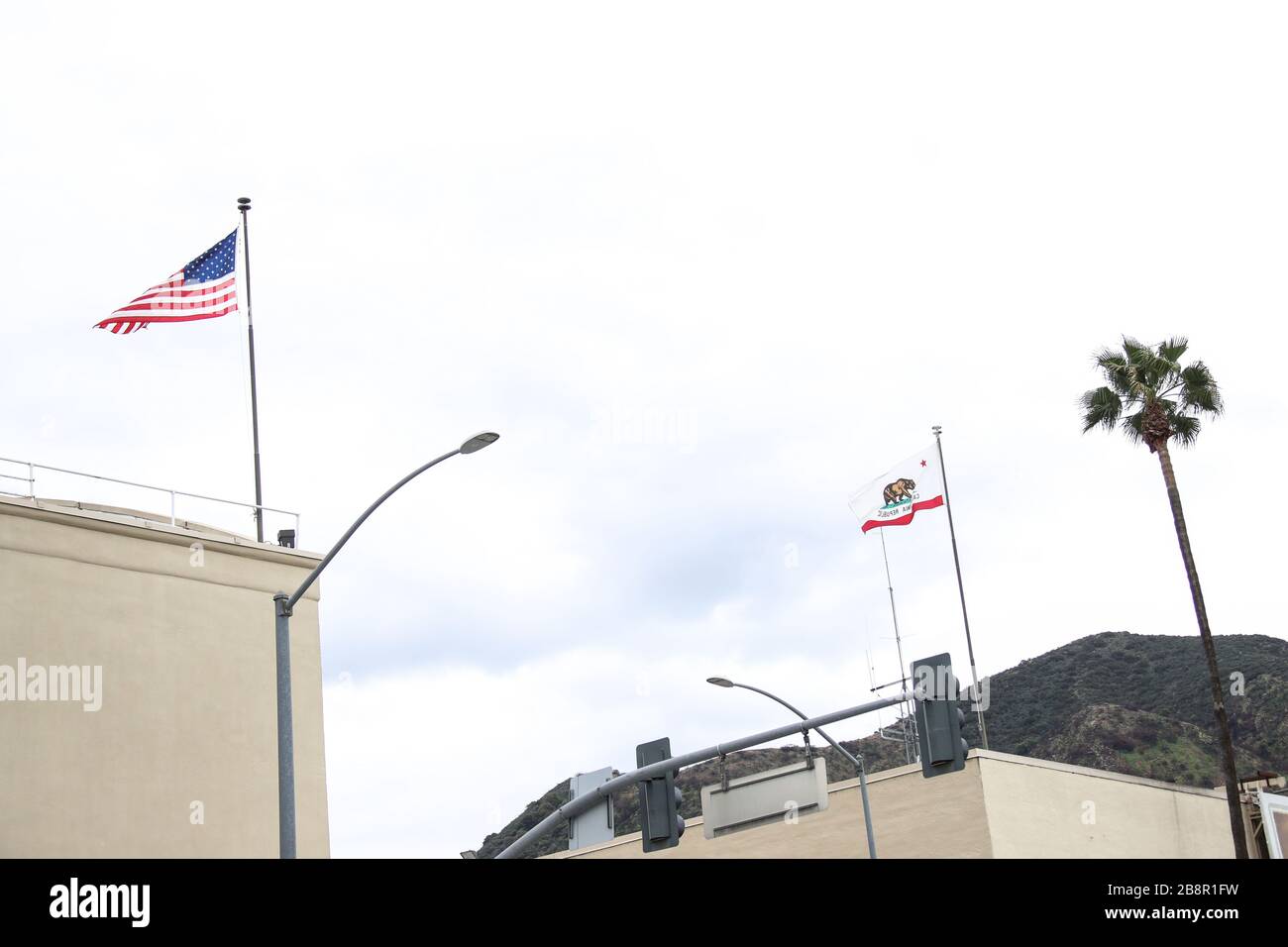 Burbank, California, USA. 22nd March, 2020. Flags of the United States and California Republic at Warner Bros. Studios in Burbank, temporarily closed in response to coronavirus COVID-19 pandemic, three days after the 'Safer at Home' order issued by both Los Angeles Mayor Eric Garcetti at the county level and California Governor Gavin Newsom at the state level on Thursday, March 19, 2020 which will stay in effect until at least April 19, 2020 amid the Coronavirus COVID-19 pandemic United States. Credit: Image Press Agency/Alamy Live News Stock Photo