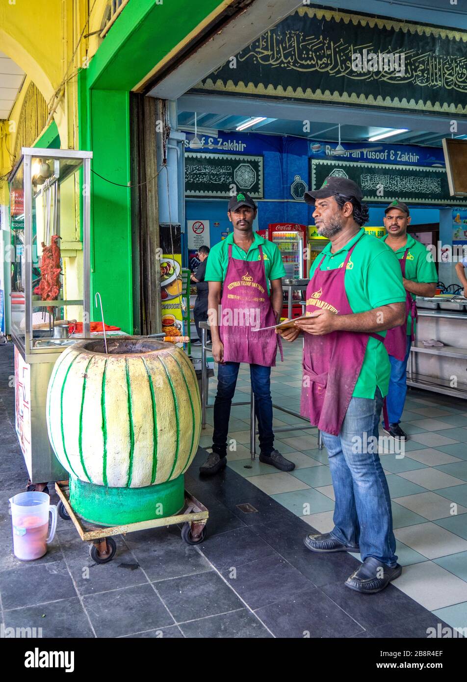 Indian restaurant cooks cooking in a mobile tandoor oven in Chinatown Kuala Lumpur Malaysia. Stock Photo