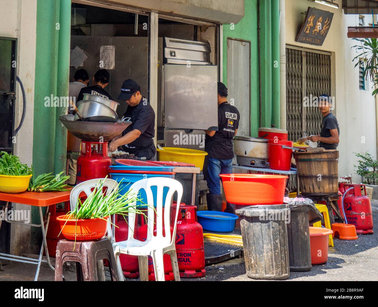 People preparing food outdoors at back of a restaurant on Lorong Panggung laneway Chinatown Kuala Lumpur Malaysia. Stock Photo