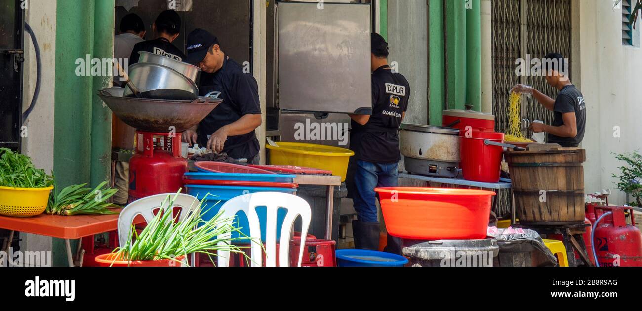 People preparing food outdoors at back of a restaurant on Lorong Panggung laneway Chinatown Kuala Lumpur Malaysia. Stock Photo
