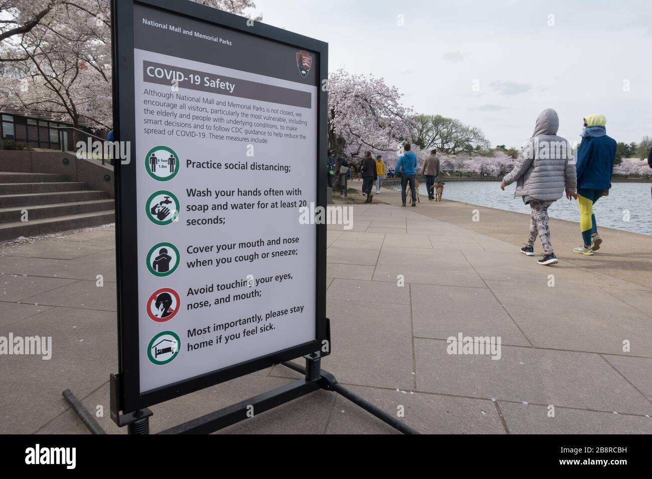Washington, DC - Mar. 22, 2020: COVID-19 information signs urge safety precautions at the Tidal Basin where residents and tourists normally flock to see the famed cherry blossoms. City officials closed surrounding streets to vehicle traffic, and two Metro stations to minimize the number of visitors and possible contagion. Stock Photo