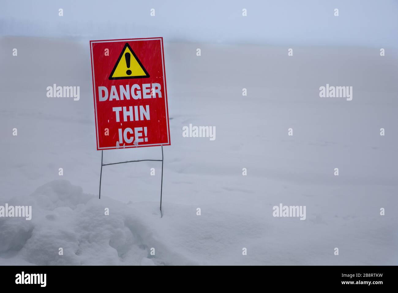 thin ice warning near a frozen lake Stock Photo