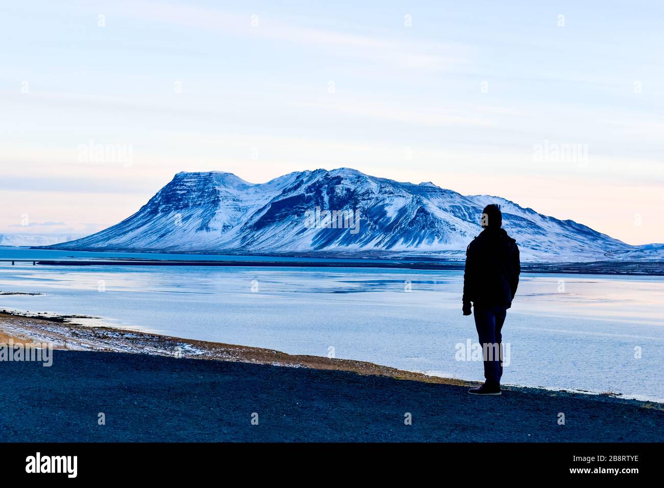 A male traveler looking at the roadside view from Snæfellsnesvegur Stock Photo