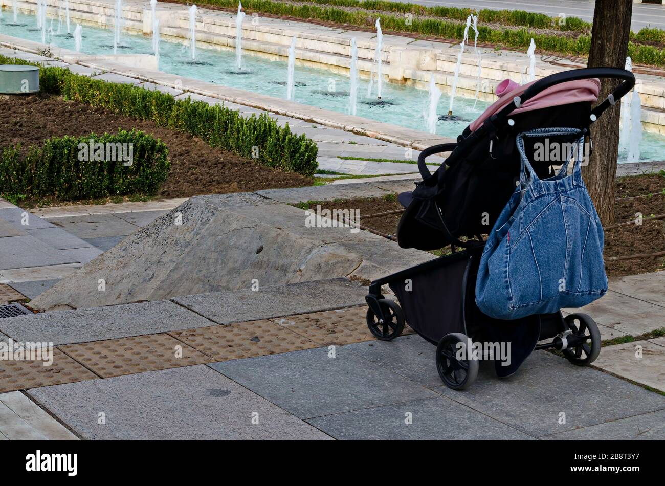 Photo of a stroller near the water fountains in front of the National Palace of Culture, suitable for cool Bulgarian beauty, Sofia, Bulgaria Stock Photo