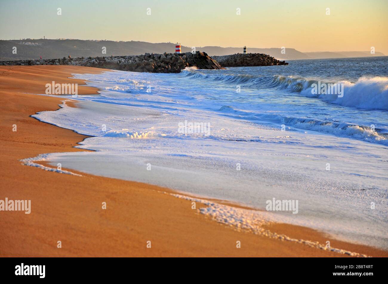 Scenic sunset view of Nazare beach with lighthouse, Portugal Stock Photo