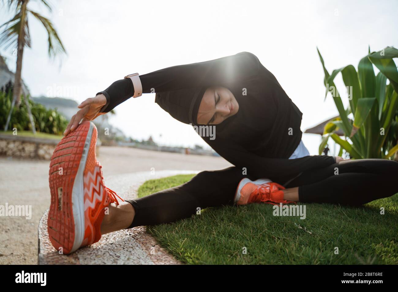 woman with muslim sport wear stretching. sporty female using head scarf