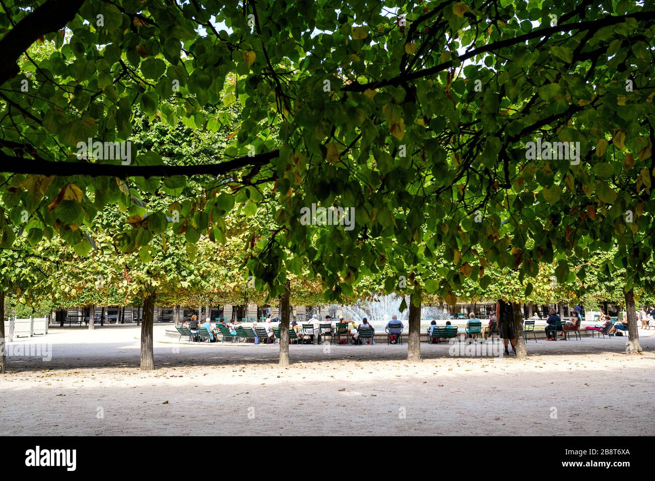 People sitting in front of the Royal Fountain by the Jardin du Palais Royal Stock Photo