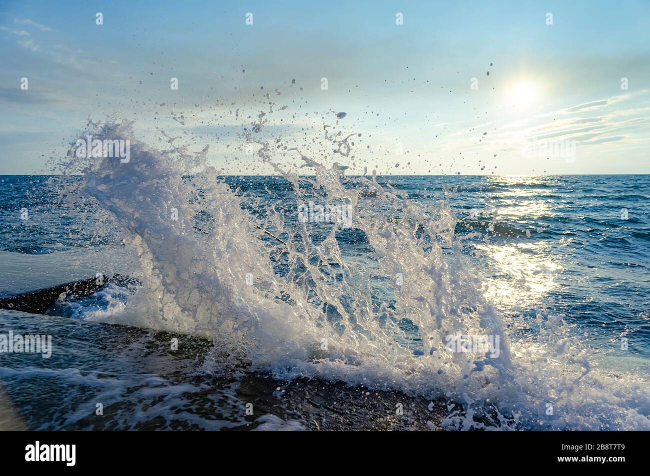 Bright sunset under the sea with waves splashes and stones Stock Photo ...
