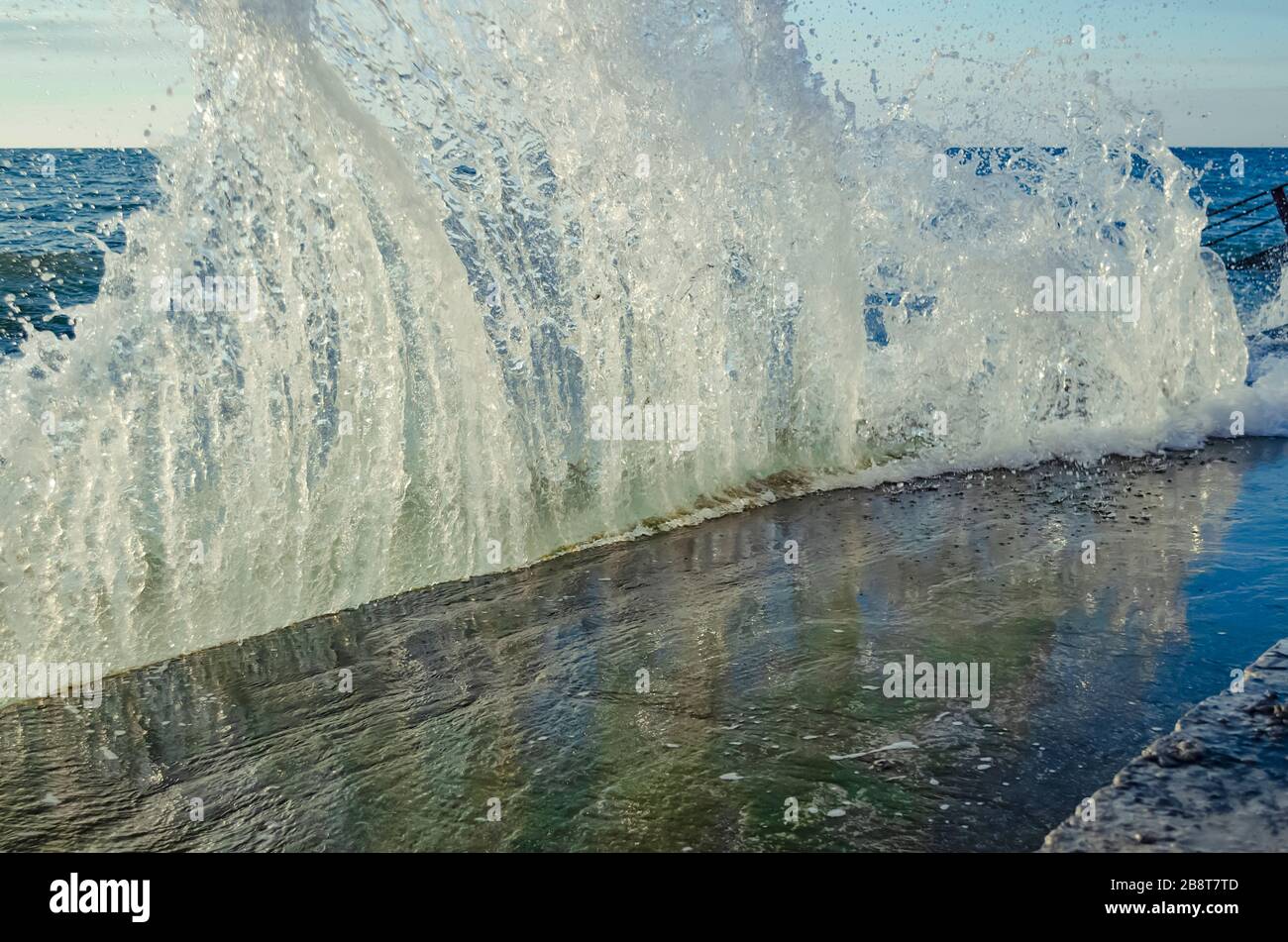 Bright sunset under the sea with waves splashes and stones Stock Photo ...
