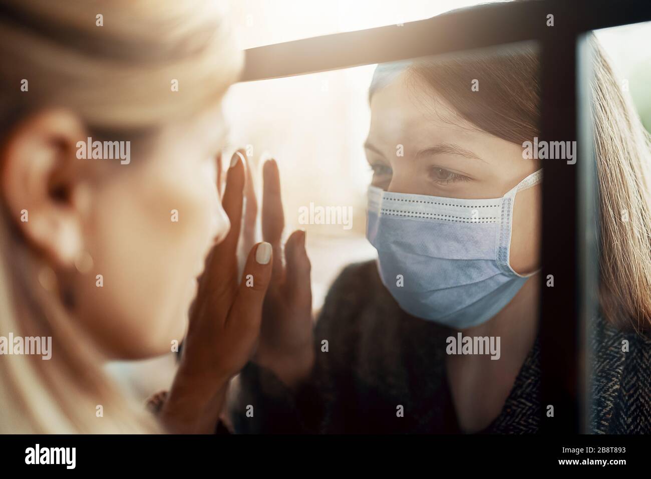 Mother and daughter are separated because of the quarantine Corona Virus Covid-19, social distancing Stock Photo
