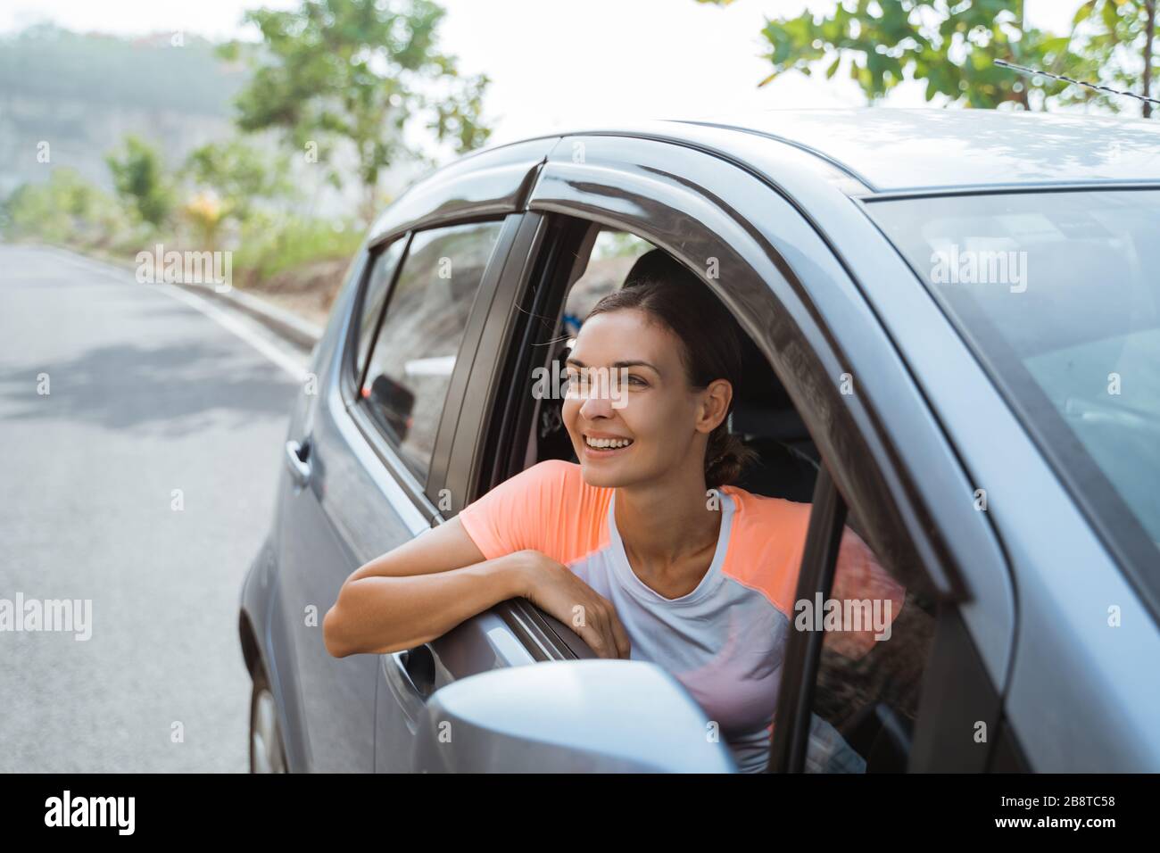 happy young woman smiling while sitting in her car Stock Photo - Alamy